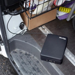 Schwarze Master Lock Sicherheitskassette mit Kabel zur Befestigung im Auto.