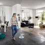 Frau wischt mit Leifheit Clean Twist Disc Mop Ergo Micro Duo den Boden im Wohnzimmer.
