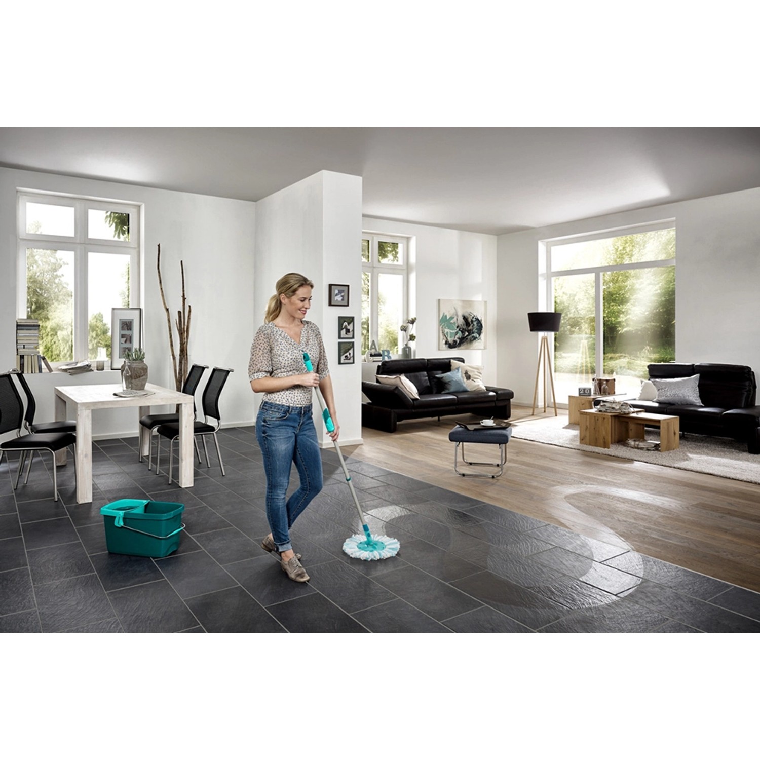 Frau wischt mit Leifheit Clean Twist Disc Mop Ergo Micro Duo den Boden im Wohnzimmer.