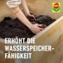 Hände füllen Hochbeeterde (Compo Bio Gärtner-Kompost) in ein Hochbeet.