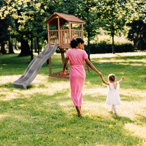 Axi Beach Tower Spielturm mit grauer Rutsche im Garten, Mutter und Kind im Vordergrund.