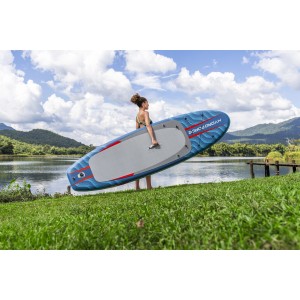 Frau trägt blaues Bestway SUP Allround Board Oceana (305 cm) am See.