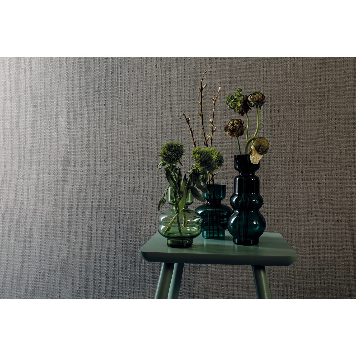 Marburg Vliestapete Struktur Kringeloptik Grau an Wand, mit Vasen auf Tisch.