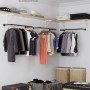 Schwarze Songmics Kleiderstange zur Wandbefestigung mit Kleidung in Ankleidezimmer.