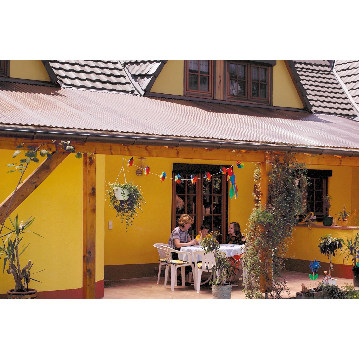 Terrasse mit Acryl-Profilplatte Sinus 76/18 Wabe Bronze als Bedachung.