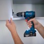 Bosch Professional Akku-Schlagbohrschrauber beim Schrauben in einen Schrank.