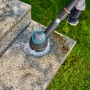 Gardena AquaBrush Universal Akku-Multi-Reiniger im Einsatz auf Steinfläche.