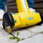Gloria MultiBrush li-on Plus Akku-Fugenbürste im Einsatz gegen Unkraut auf Pflastersteinen.