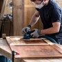 Mann schleift Holz mit Bosch Schwingschleifer und Expert Netzschleifblatt M480.