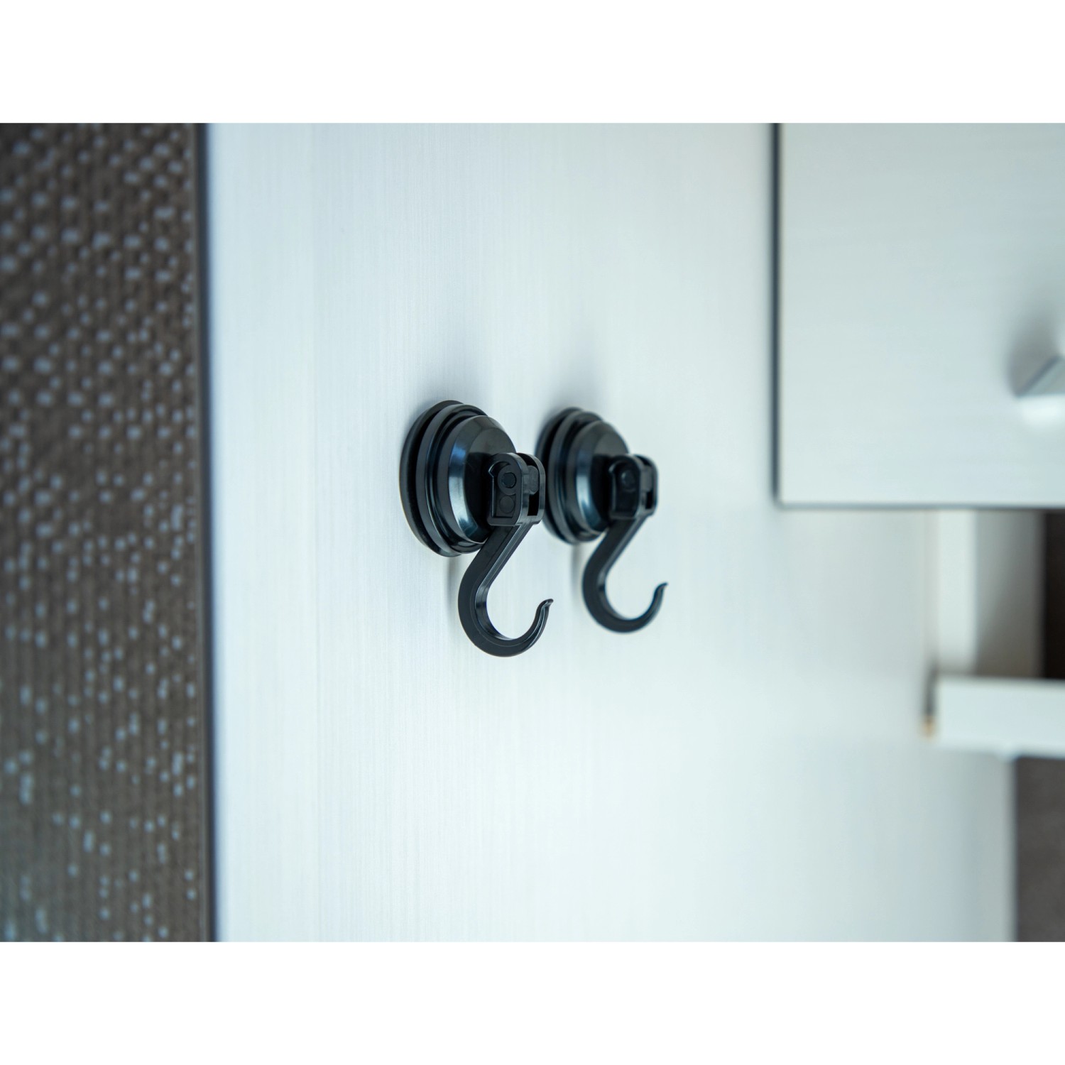 Zwei schwarze Cartrend Saughaken (4 kg) an einer weißen Oberfläche befestigt.