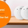 Smartwares Rauchmelder 3er-Set RM520/3: Drei weiße Rauchmelder auf einem Holzregal.