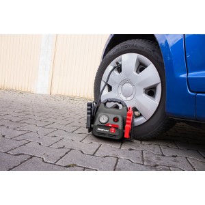 APA Starthilfe Powerpack mit Kompressor beim Aufpumpen eines Autoreifens.