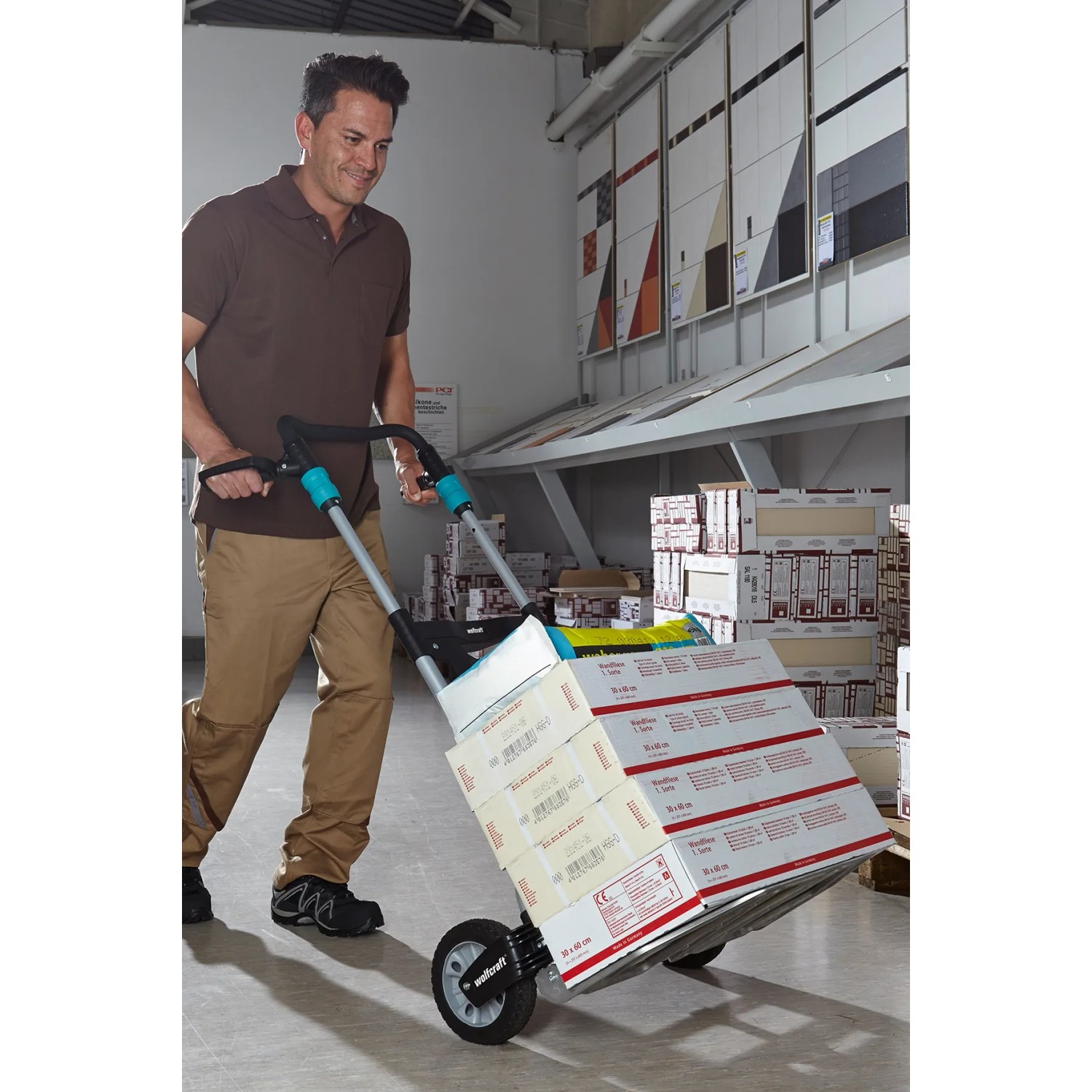 Mann transportiert Kartons mit der klappbaren wolfcraft Sackkarre TS 1500.