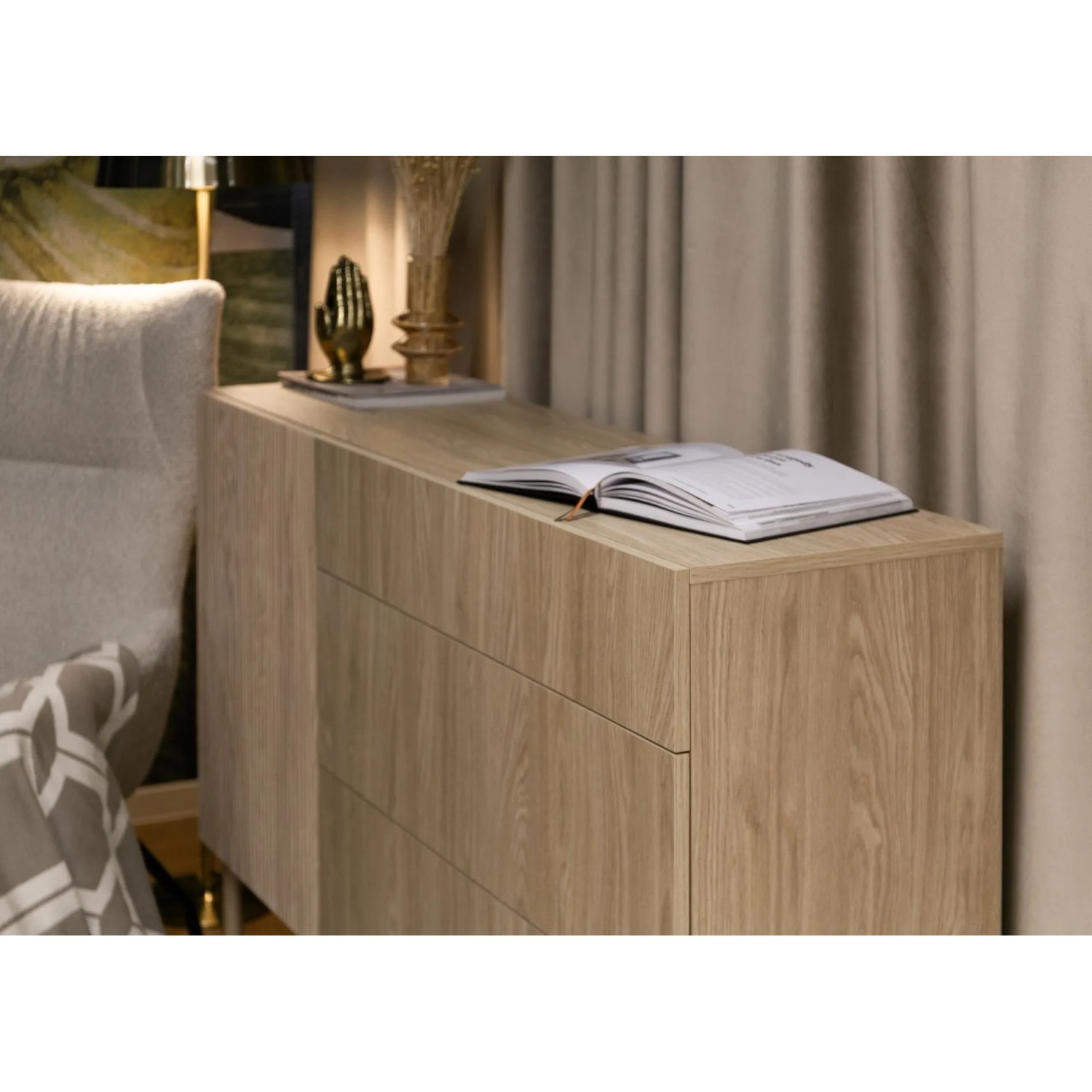 Helles Selsey Sideboard Nolie in geölter Eiche Optik mit drei Schubladen. Buch und Deko auf der Oberfläche.