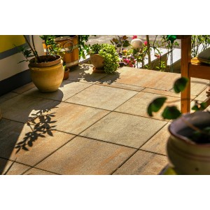 Verlegte Terrassenplatten Modern Muschelkalk 40x40 cm auf einer Terrasse mit Pflanzen.