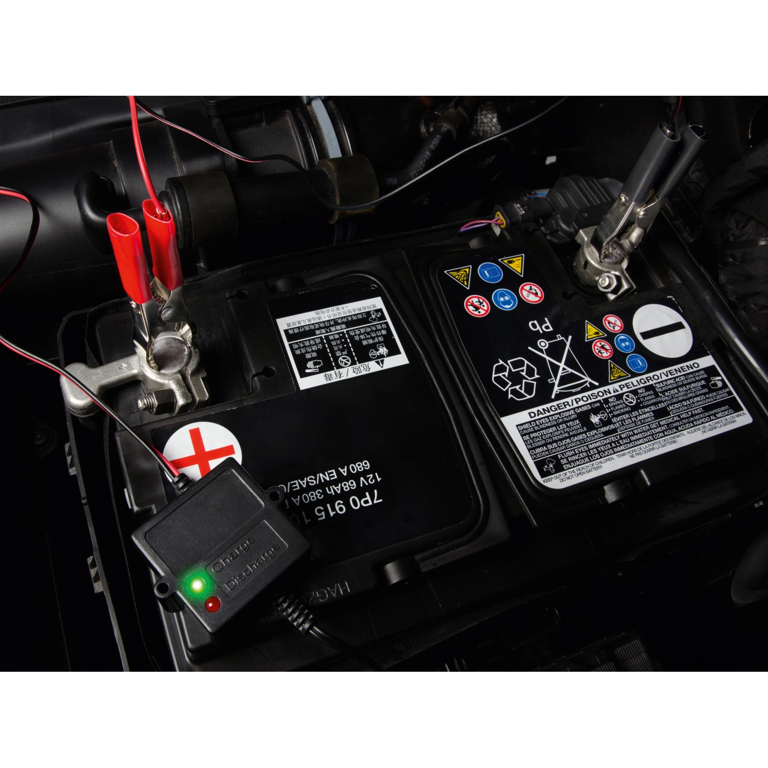 CMI Batterie-Erhaltungsladegerät an Autobatterie mit Klemmen und Kontrollleuchte.