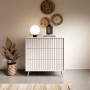 Weiße Selsey Bello Kommode mit drei Schubladen, Lamellendekor und goldenen Beinen im modernen Wohnzimmer.