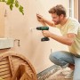 Mann bohrt mit Bosch 18V Akku-Schlagbohrschrauber in Wand. Inkl. Akku und Koffer.