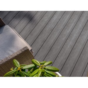 Graue Rettenmeier WPC Terrassendielen Esche, geriffelt, mit Gartenmöbeln und Pflanze.