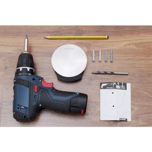 Wagner Bodentürstopper EH5152 Schwarz mit Montagezubehör und Werkzeug auf Holz.