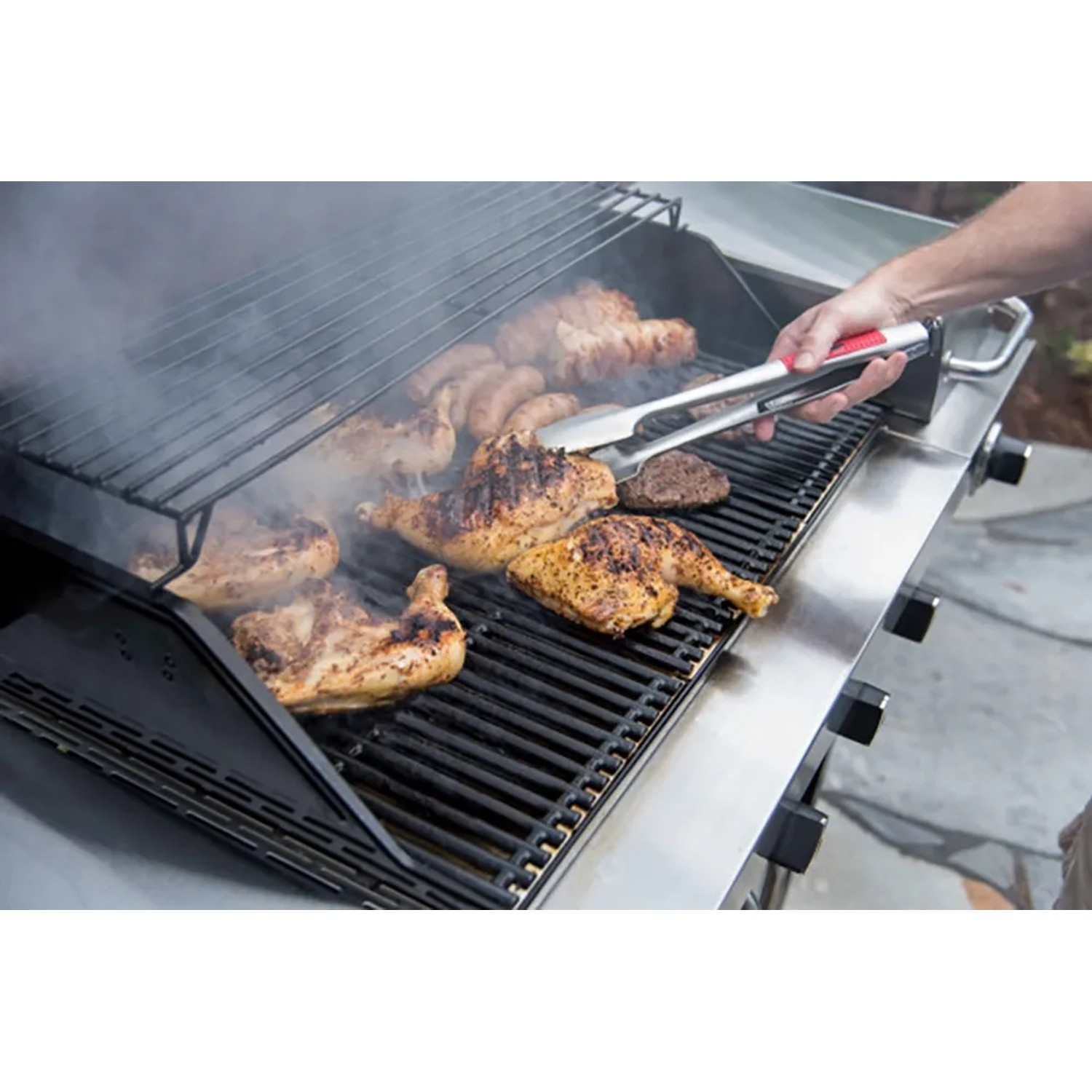 Char-Broil Grillzange Comfort Grip im Einsatz: Grillgut (Hähnchen, Wurst) wird gewendet.