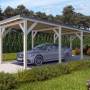 Holzbrüder Einzelcarport Ralf Natur mit dunkelgrauem Blechdach und Auto.