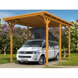 Skan Holz Carport Emsland Caravan, Eiche hell, mit untergestelltem VW Bus vor blühenden Büschen.