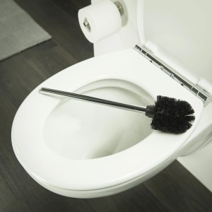 Tiger Ersatz-WC-Bürste mit Stiel, Chrom und Schwarz, auf einer Toilette liegend.