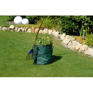 Grüner Gartensack Pop Up (85 l) mit Gartenabfällen und Rechen auf Rasen.