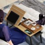 HOMCOM Laptoptisch aus Bambus und Eiche auf Bett genutzt. Höhenverstellbar, neigbare Platte mit Tablet, Ablage mit Schublade.