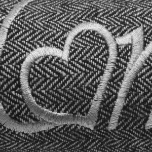 Detailaufnahme: Anthrazitfarbener Beautissu Tuuli Zugluftstopper mit Herz-Stickerei.