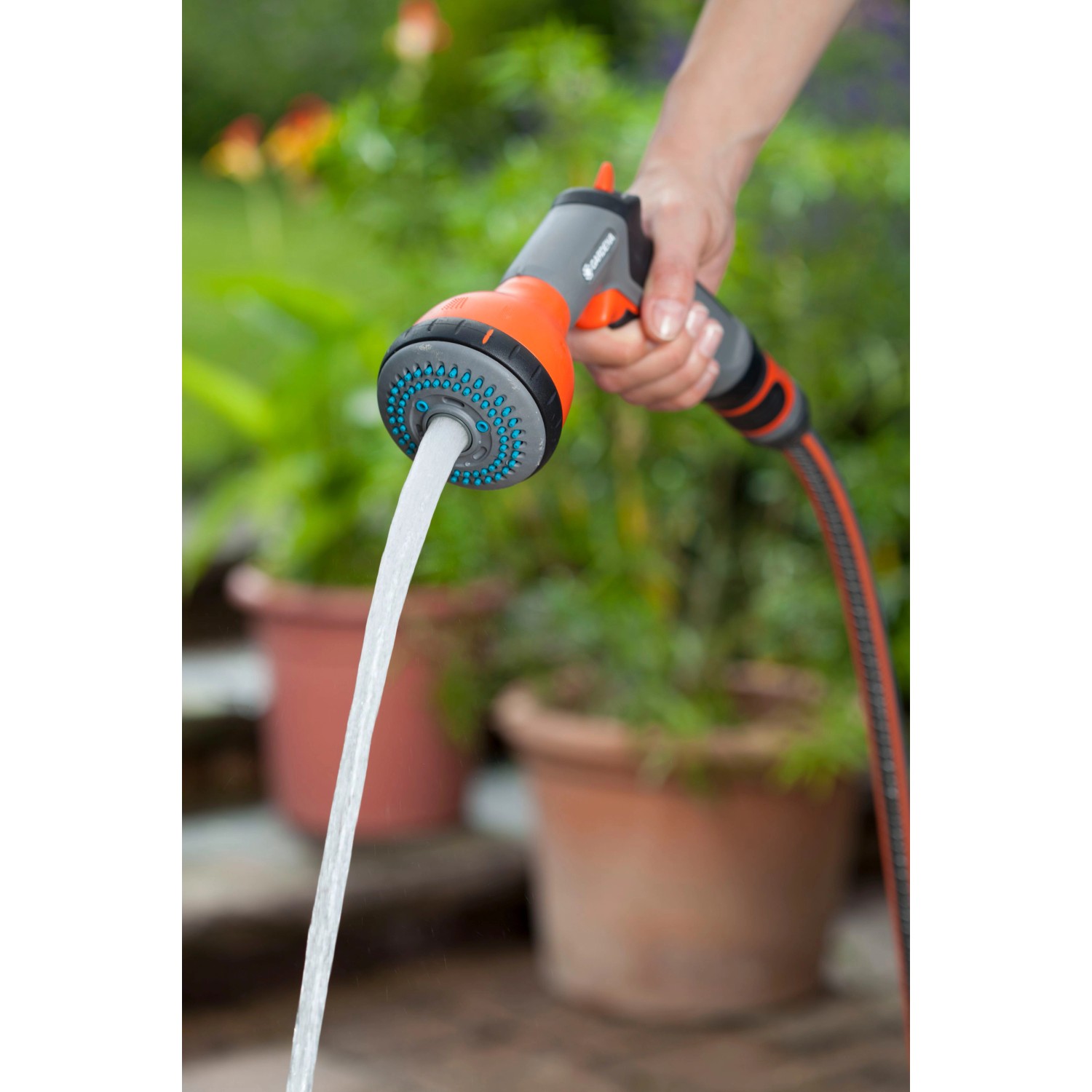 Gardena Classic Multibrause in Aktion: Wasserstrahl für Gartenbewässerung und Reinigung.