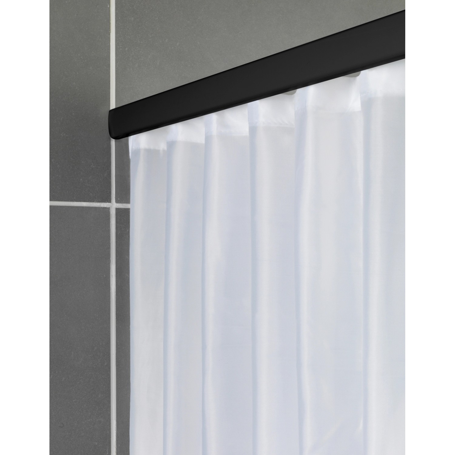 Schwarze Schöner Wohnen Duschstange Jete mit weißem Duschvorhang an grauer Wand.