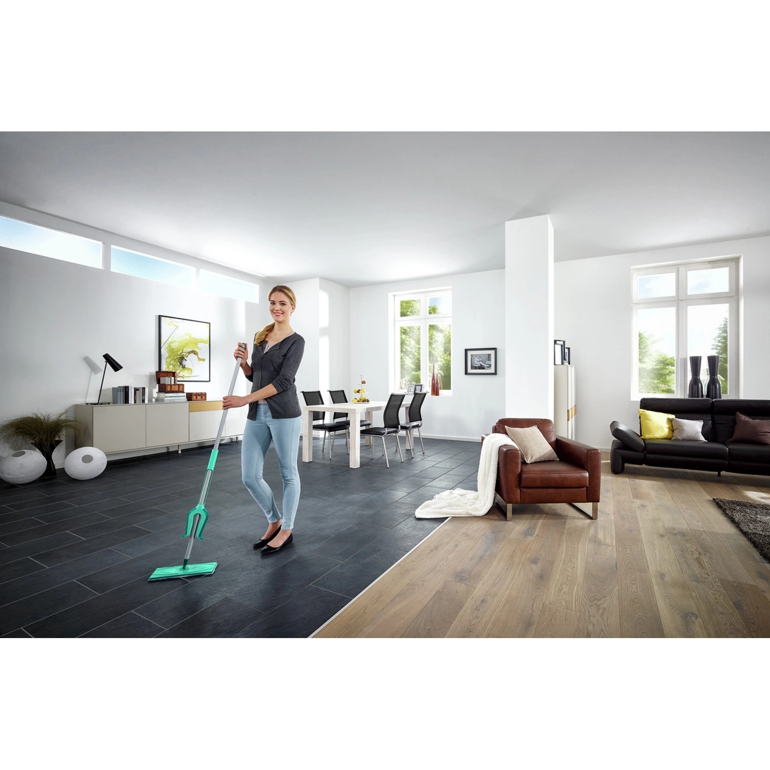 Frau wischt Boden mit Leifheit Picobello XL micro duo Bodenwischer in modernem Wohnzimmer.