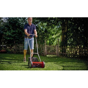 Mann mäht Rasen mit dem roten Einhell Hand-Rasenmäher GC-HM 300 im Garten.