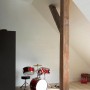 Helle Räumlichkeit mit Parador Dekor-Paneelen in Esche Weiß Glänzend und Schlagzeug.