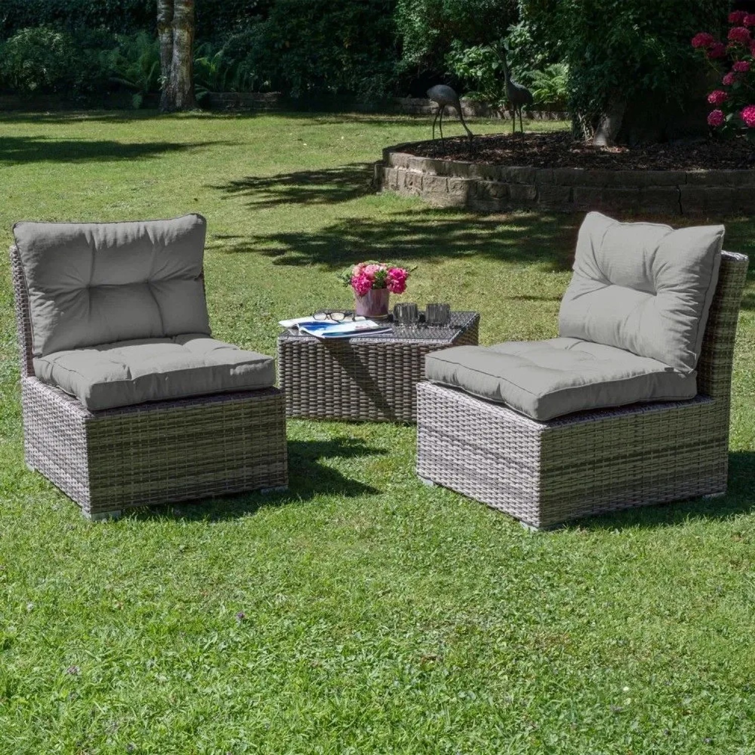 Hellgraue Beautissu Xluna Rücken- und Sitzkissen auf Lounge-Gartenstühlen im Garten. Ideal für Rattanmöbel.