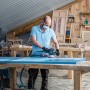 Handwerker schleift blaue Holzplatte mit Bosch Exzenterschleifer und Schleifblatt C470.