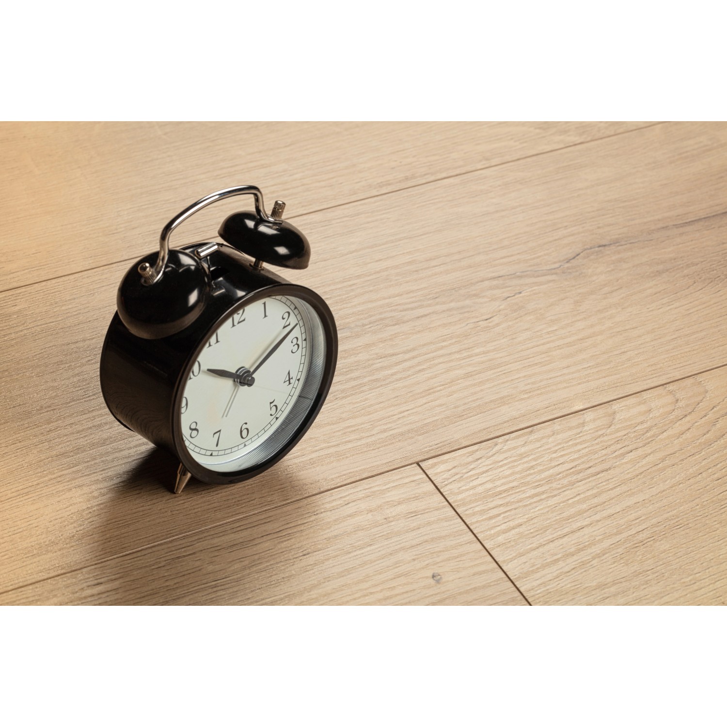 Kaindl Laminat Poseidon California Oak, wasserfest, mit schwarzem Wecker auf dem Boden.