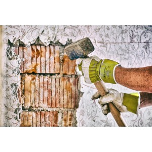 Hände mit Gebol Worker Pro Arbeitshandschuhen Größe 9 beim Stemmen einer Wand mit einem Hammer.