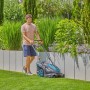 Mann mäht Rasen mit Gardena Akku-Rasenmäher PowerMax Duo 46/36 V. Rasenpflege im Garten.