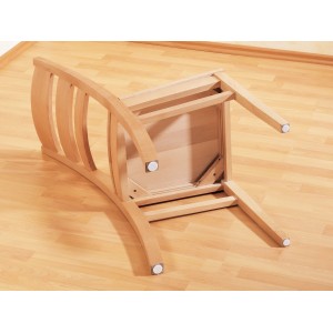 Holzstuhl (umgedreht) mit weißen Filzgleitern zum Schutz des Bodens.