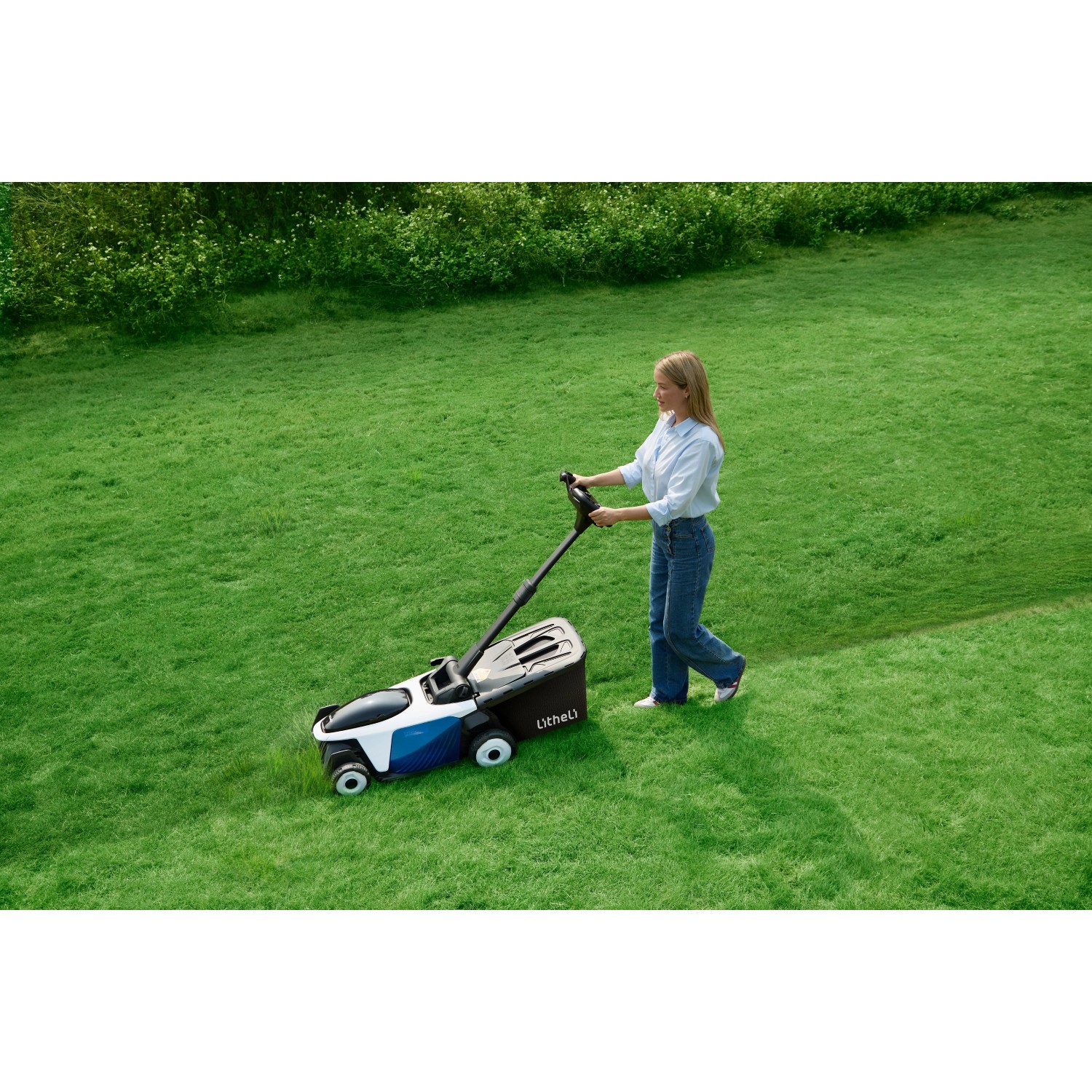 Frau mäht Rasen mit Litheli Akku-Rasenmäher EasySurge, inkl. 2 Akkus.