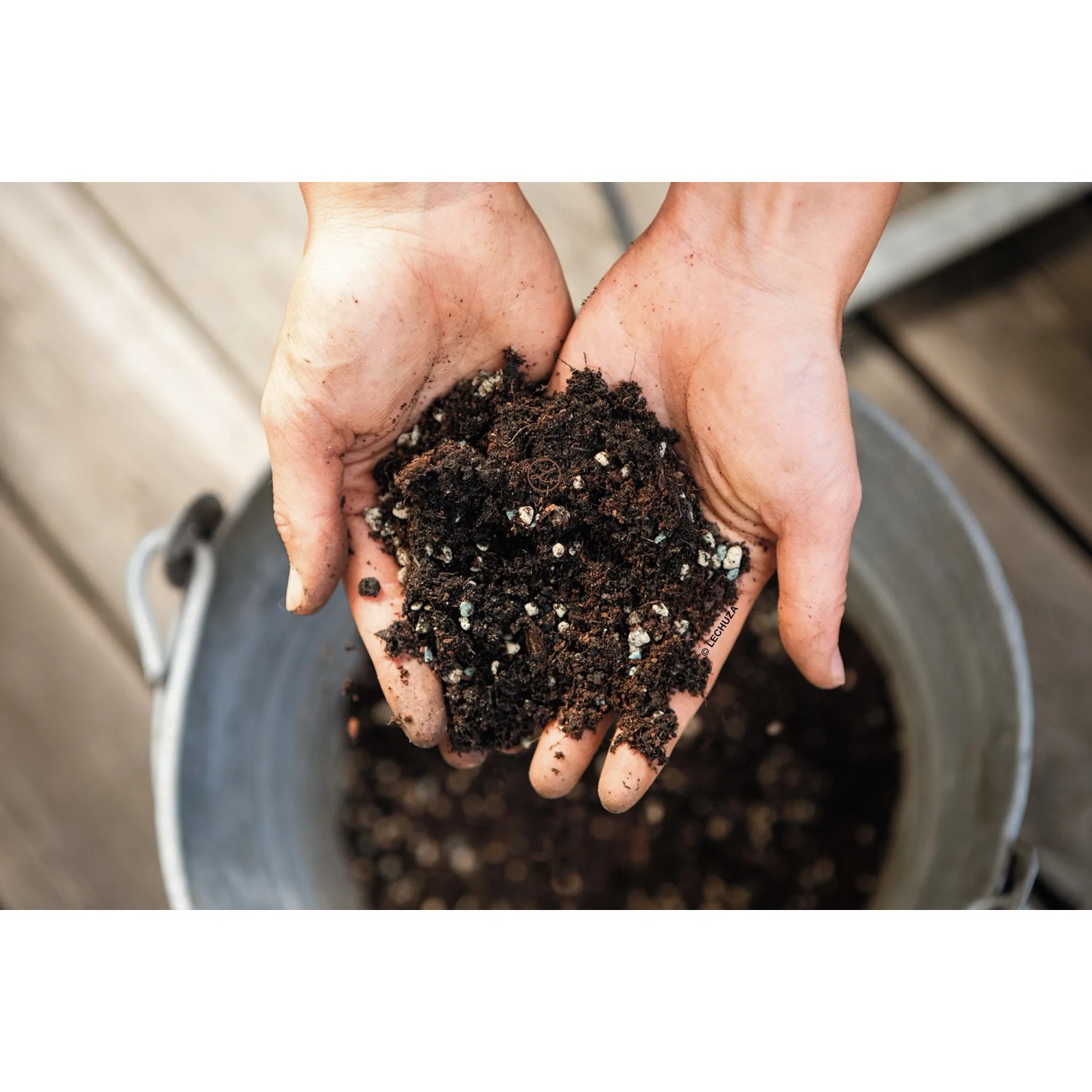 Hände halten Lechuza Veggiepon Pflanzsubstrat für Gemüse und Obst, torffrei und vegan.