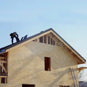 Hausbau mit Kronospan OSB-3 Verlegeplatten als Wandverkleidung. Holzhaus im Rohbau.