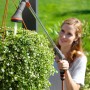 Frau gießt Blumenampel mit Gardena Comfort Gießstab. Gartenspritze mit schwenkbarem Kopf.