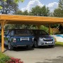 Skan Holz Carport Spessart, Eiche hell, Doppelcarport mit zwei geparkten Autos.