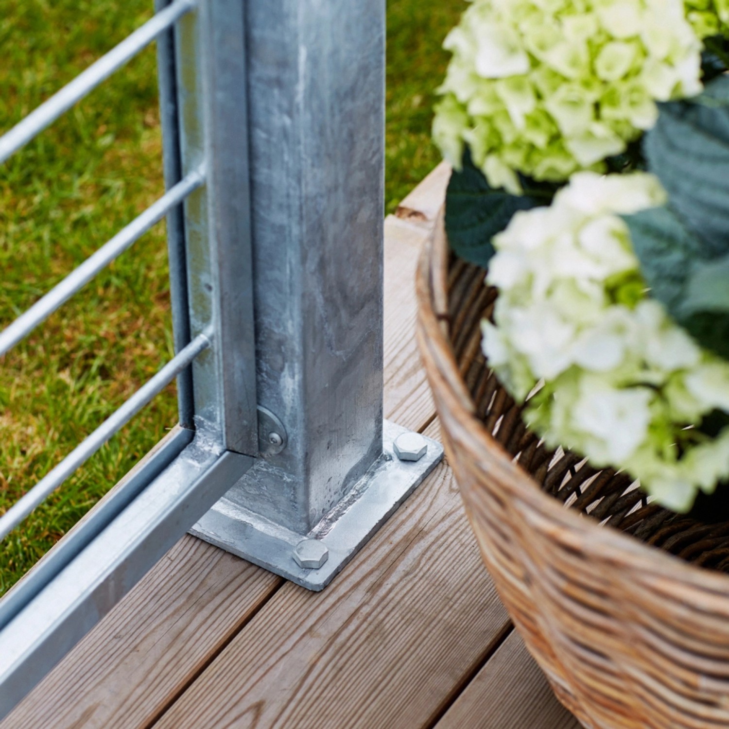Feuerverzinkter Stahl Zaunpfosten (8x8x96 cm) mit Montagefuß auf Holzterrasse.
