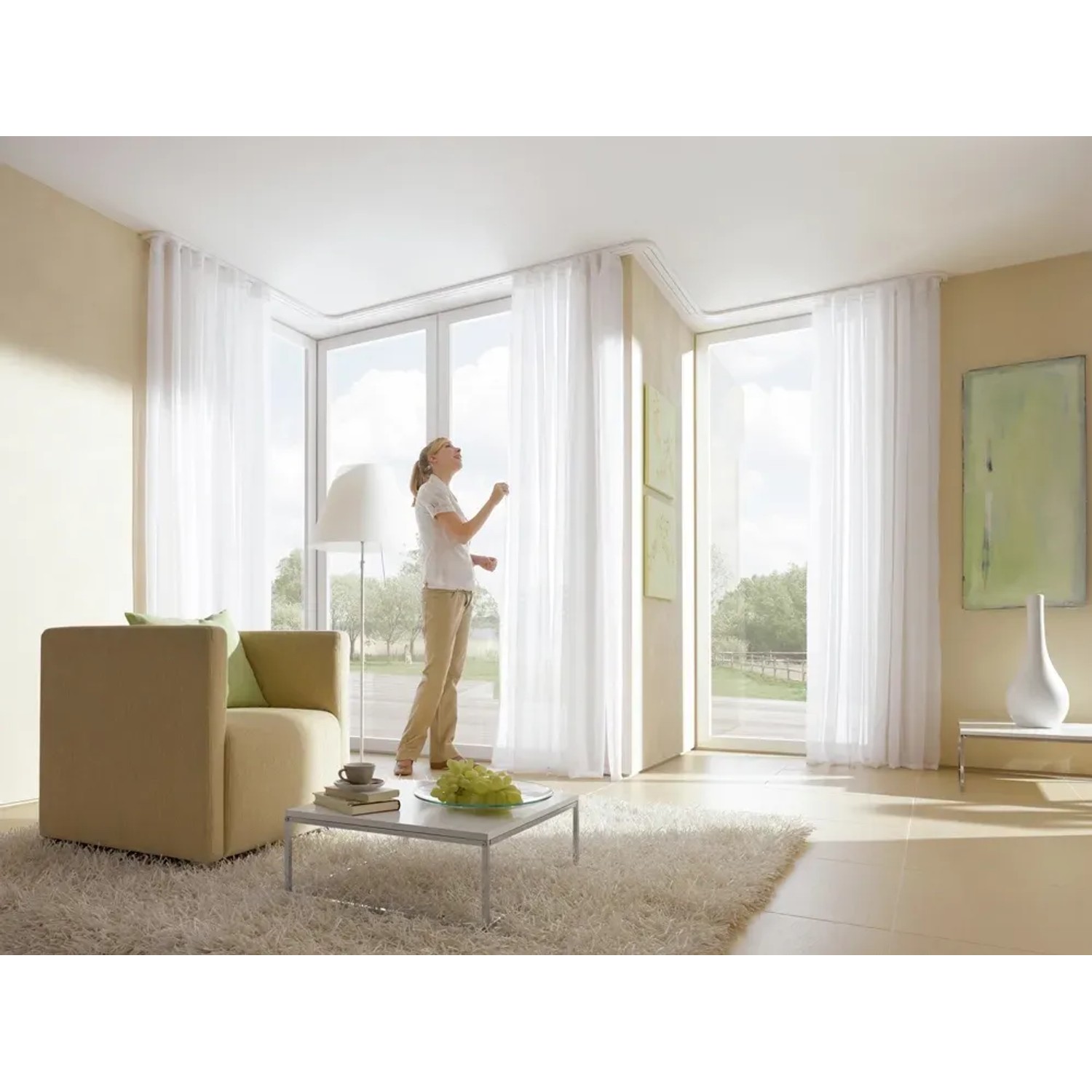 Helle Wohnraum-Szene mit weißer, 2-läufiger Gardinia Vorhangschiene GE2 (250 cm) mit Vorhängen.