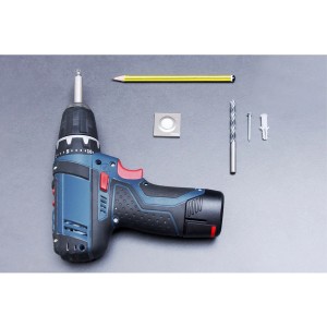 Wandtürstopper von Wagner in Edelstahl-Optik mit Bohrmaschine, Dübel, Schraube, Bleistift und Bohrer.